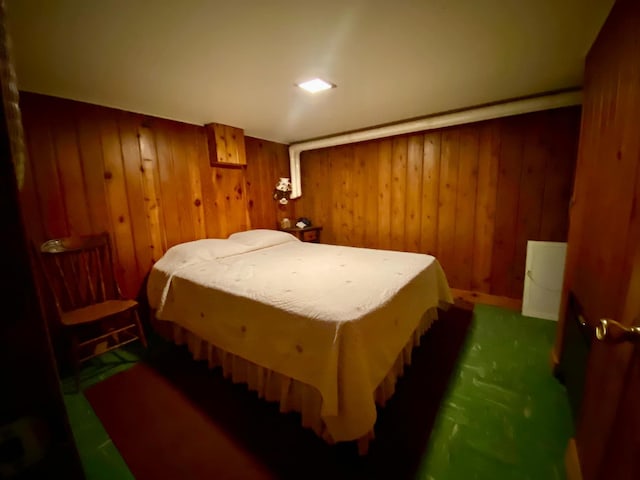 bedroom with dark carpet and wooden walls