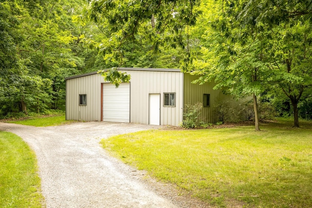 view of outbuilding featuring a lawn and a garage