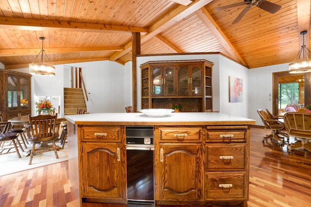 kitchen with lofted ceiling with beams, light wood-type flooring, and pendant lighting