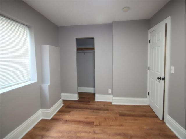 unfurnished bedroom featuring a closet and hardwood / wood-style floors