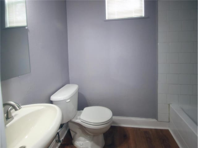 full bathroom with sink, shower with separate bathtub, wood-type flooring, and toilet