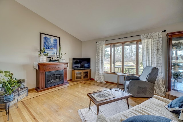 living room featuring wood-type flooring and vaulted ceiling