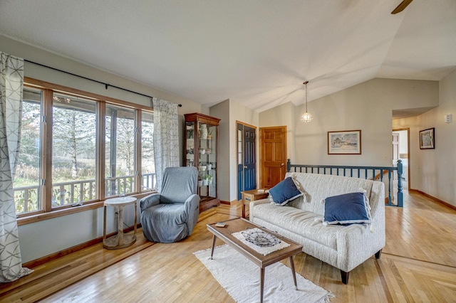 living room with light hardwood / wood-style floors and vaulted ceiling