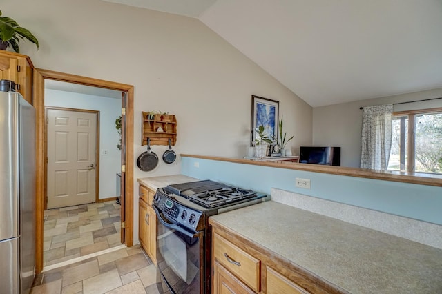 kitchen featuring stainless steel refrigerator, lofted ceiling, and black stove