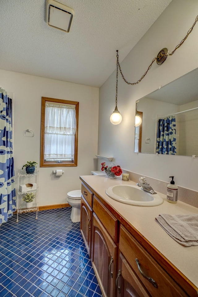 bathroom featuring toilet, a textured ceiling, vanity, and tile patterned flooring