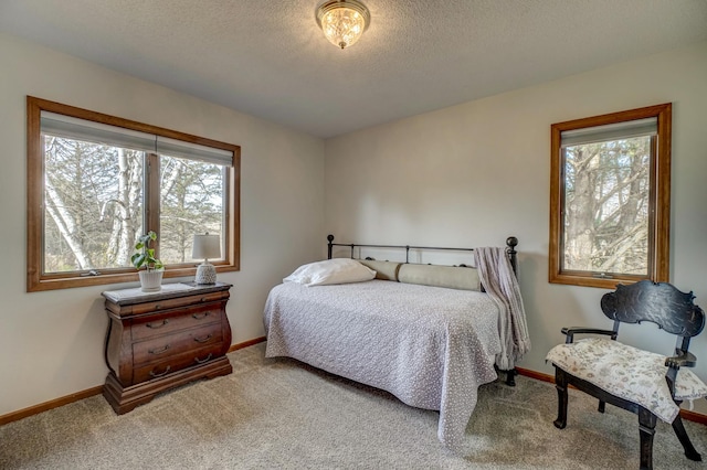 carpeted bedroom featuring a textured ceiling and multiple windows