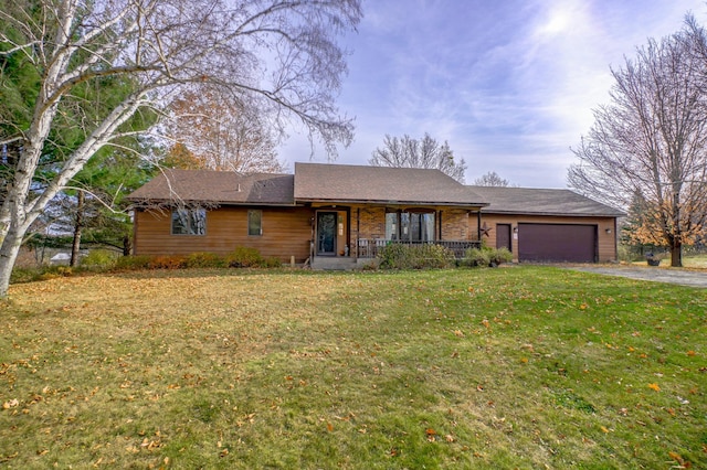 single story home with a garage, a front lawn, and a porch