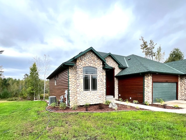 view of front of property featuring a front yard, central AC unit, and a garage