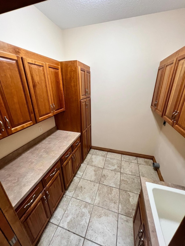 bathroom with a textured ceiling, sink, and a bathing tub