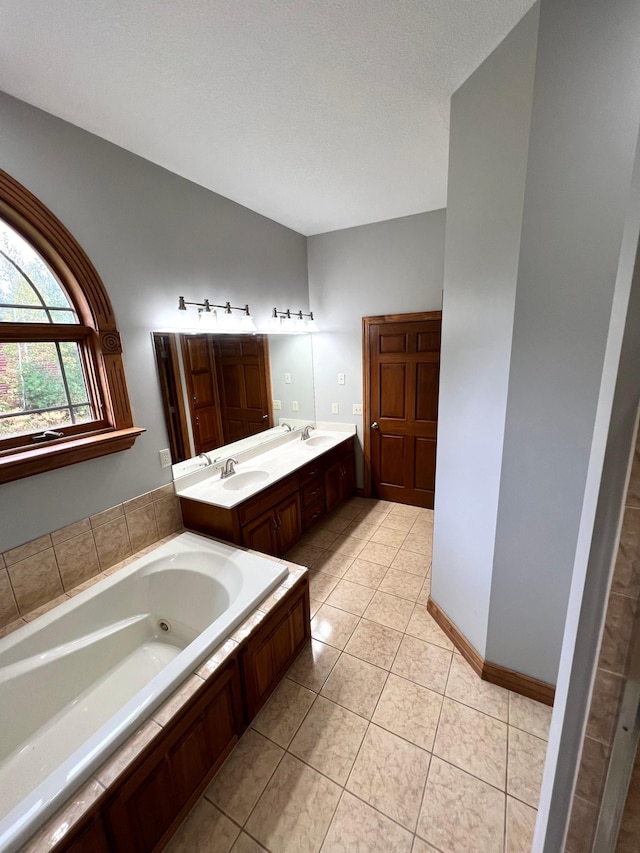 bathroom with vanity, a tub, a textured ceiling, and tile patterned floors