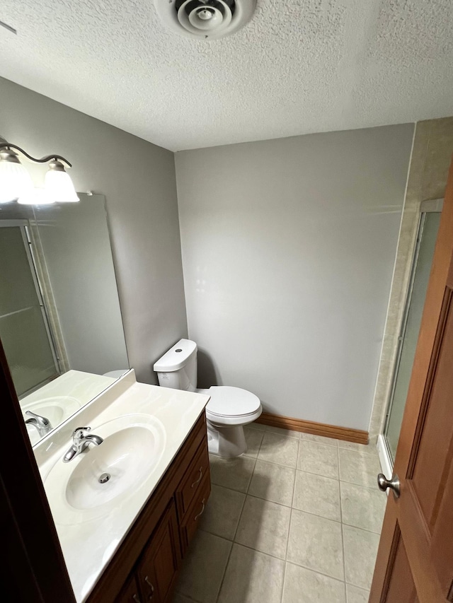 bathroom with vanity, a textured ceiling, toilet, and walk in shower