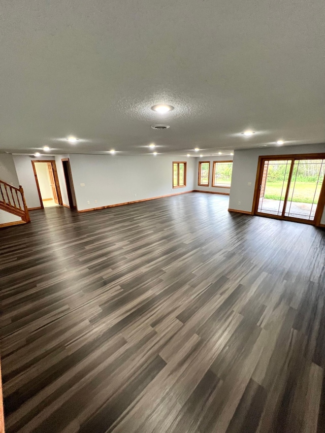 empty room with a textured ceiling and dark hardwood / wood-style flooring