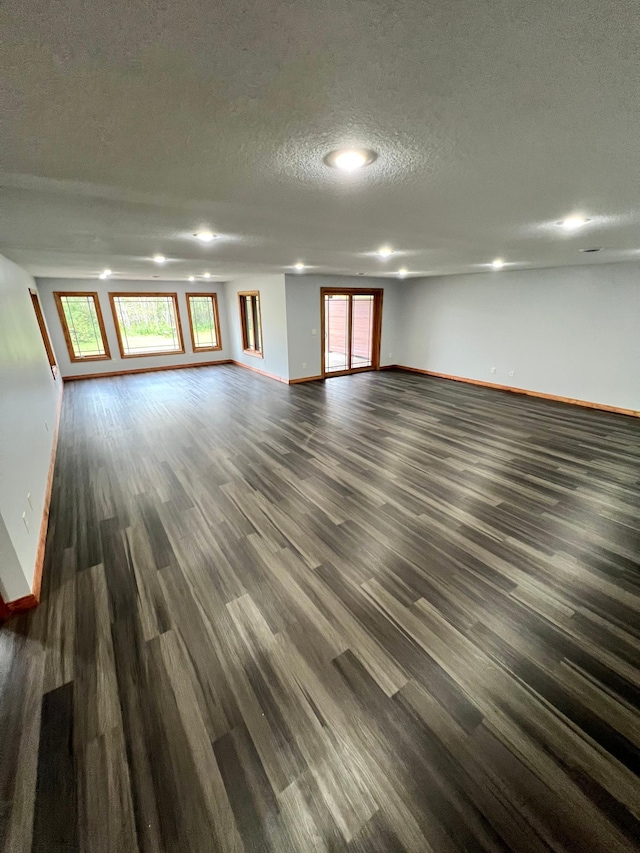 empty room featuring dark wood-type flooring and a textured ceiling