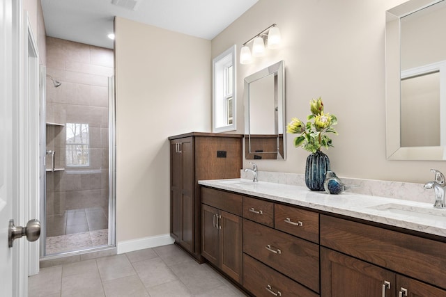 bathroom with vanity, a shower with shower door, and tile patterned floors