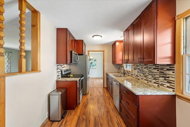 3315 Upper 143rd St W, Rosemount, MN 55068 - kitchen featuring stainless steel appliances, wood finished floors, a sink, tasteful backsplash, and a textured ceiling