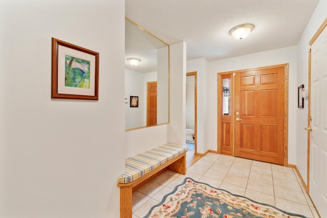 entryway with light tile patterned flooring and a textured ceiling