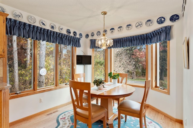 dining area featuring hardwood / wood-style flooring, an inviting chandelier, and a textured ceiling