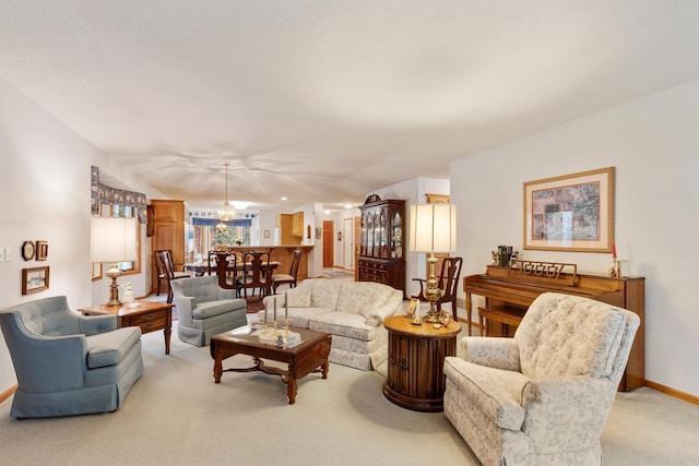 carpeted living room with a notable chandelier