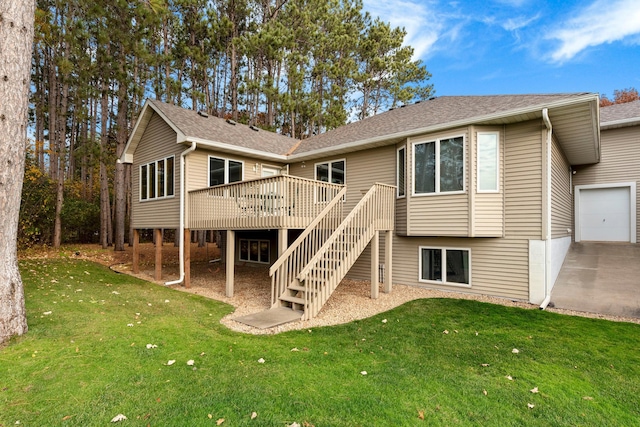 back of house with a garage, a wooden deck, and a yard