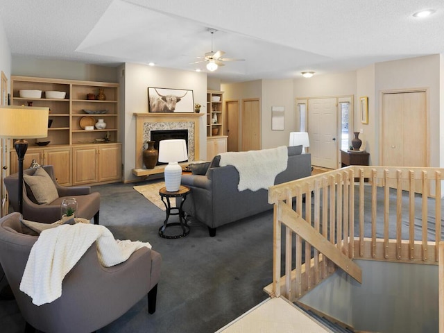 living room with ceiling fan, lofted ceiling, a fireplace, and dark colored carpet