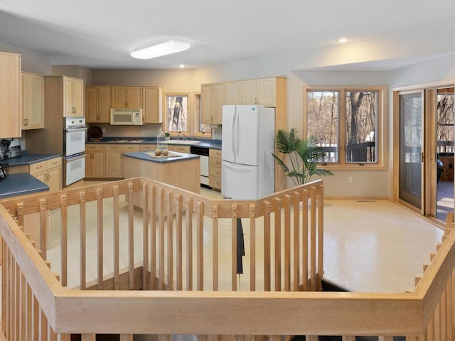 kitchen with a center island, sink, and white appliances