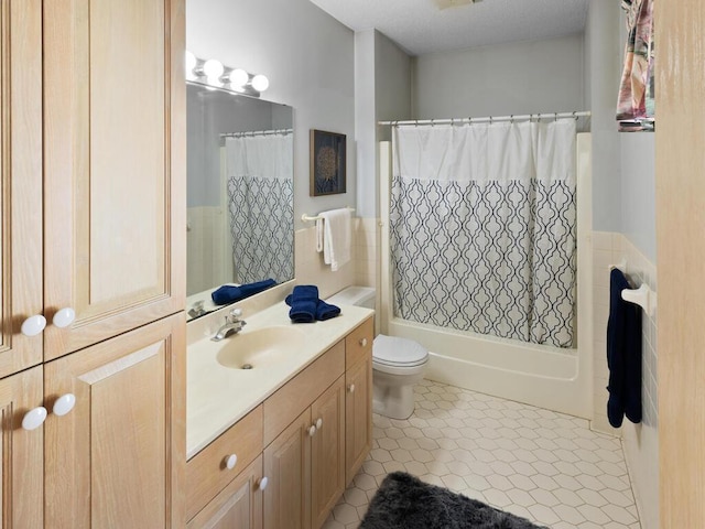 full bathroom featuring tile patterned floors, vanity, toilet, and tile walls