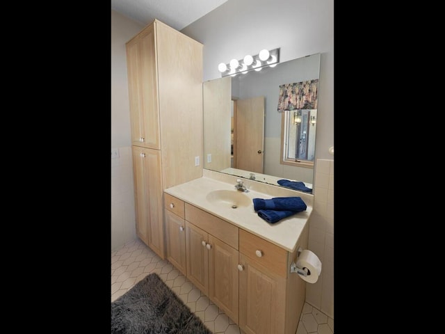 bathroom with tile patterned floors, vanity, and tile walls