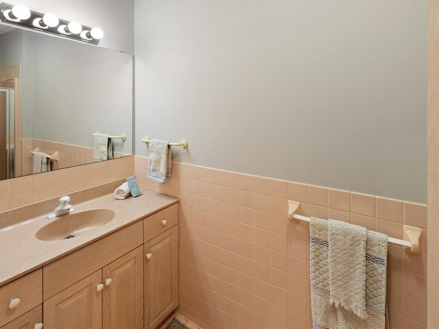 bathroom featuring tile walls, vanity, and walk in shower