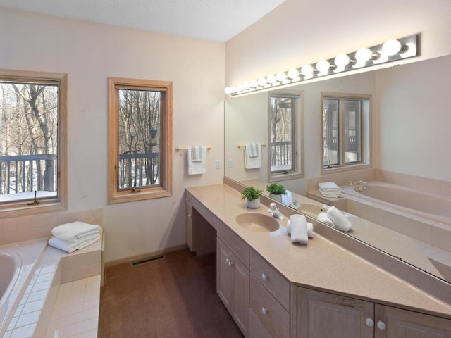 bathroom with vanity and a relaxing tiled tub