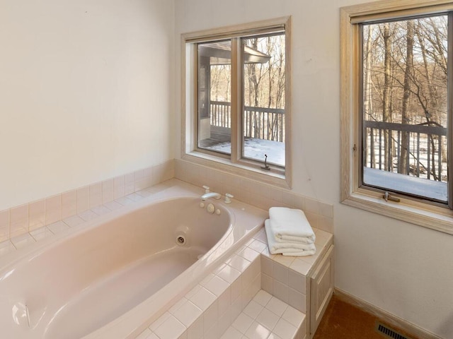 bathroom with a wealth of natural light and tiled bath