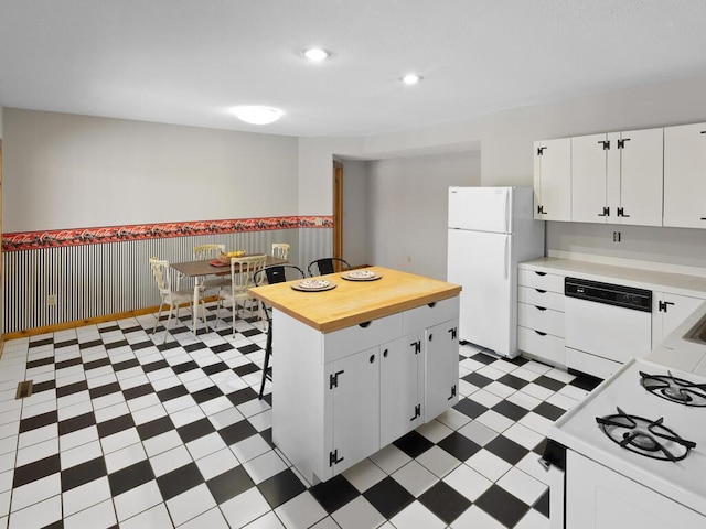 kitchen with white cabinetry, a kitchen island, and white appliances