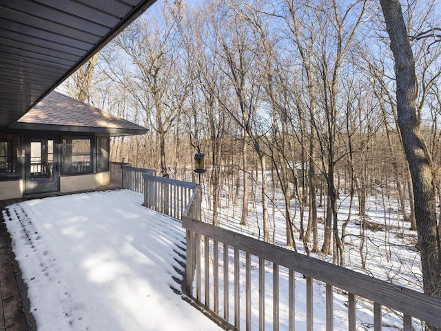 snow covered deck featuring a sunroom