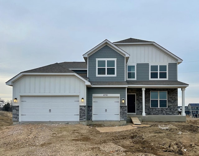 view of front of home with board and batten siding, stone siding, a porch, and a garage