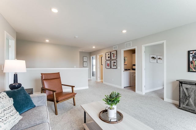 living room featuring washing machine and dryer, recessed lighting, light carpet, visible vents, and baseboards