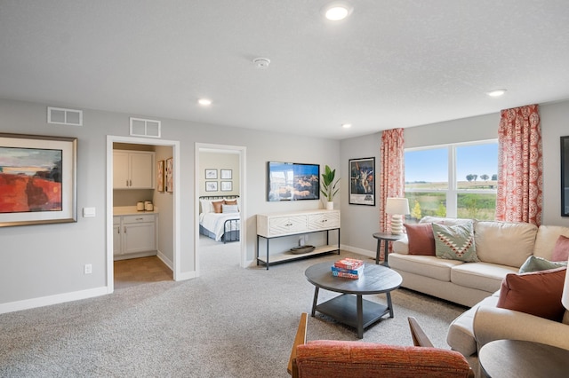 living room featuring recessed lighting, visible vents, and light carpet