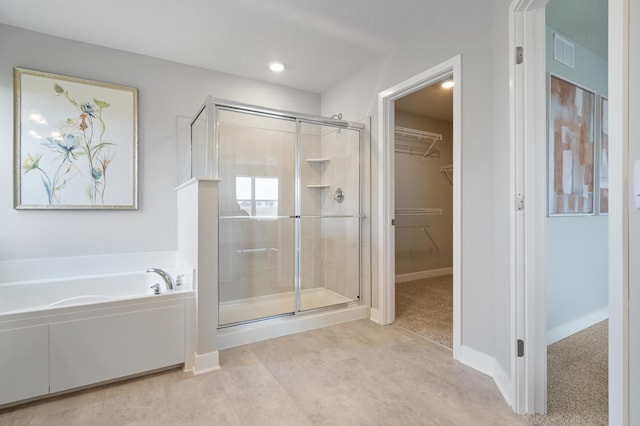 bathroom featuring a garden tub, a spacious closet, a shower stall, and visible vents