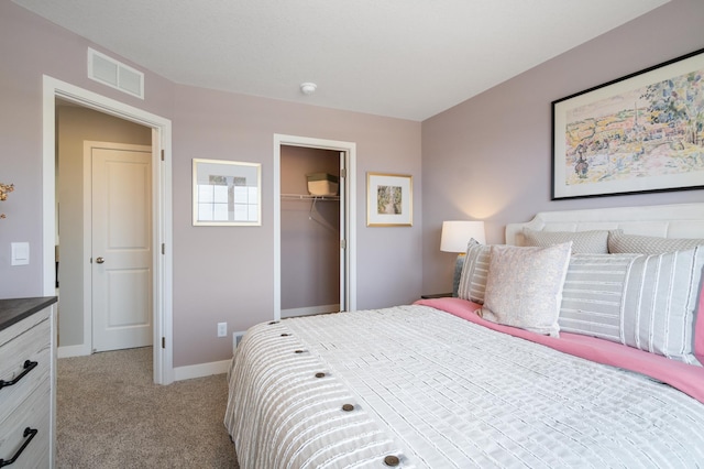 bedroom with baseboards, visible vents, a closet, and light colored carpet