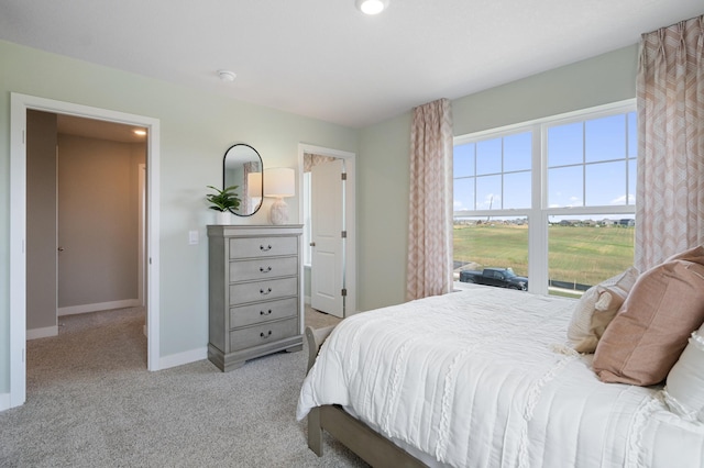 bedroom featuring light carpet and baseboards