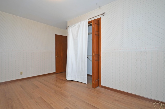 unfurnished bedroom with wood-type flooring and a closet