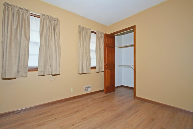 unfurnished bedroom with a closet and light wood-type flooring