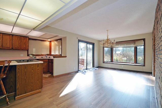 kitchen with a notable chandelier, hanging light fixtures, and light wood-type flooring