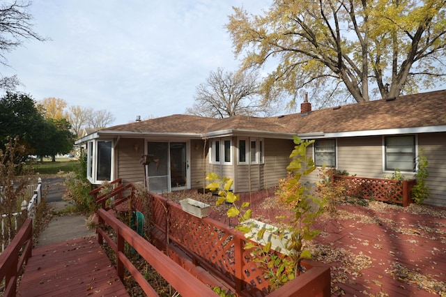 back of property with a wooden deck and a sunroom