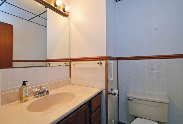 bathroom featuring tile walls, vanity, a paneled ceiling, and toilet