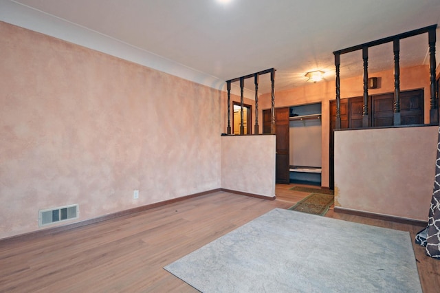 empty room featuring a baseboard heating unit and hardwood / wood-style floors