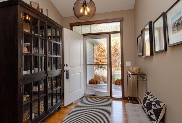 entryway with vaulted ceiling and light hardwood / wood-style floors