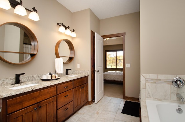 bathroom featuring vanity and tiled tub