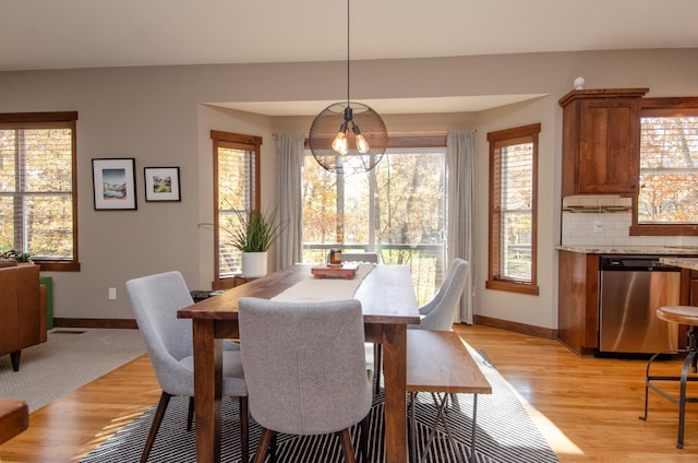 dining area featuring light wood-type flooring and a chandelier