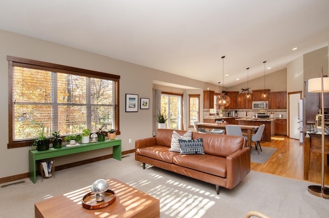 living room featuring light carpet and vaulted ceiling