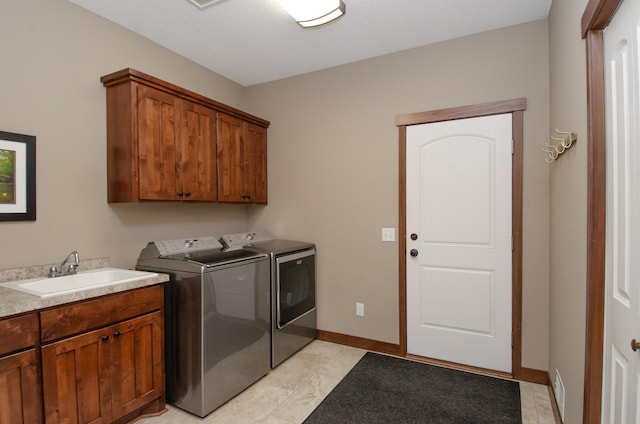 washroom with separate washer and dryer, a sink, cabinet space, and baseboards