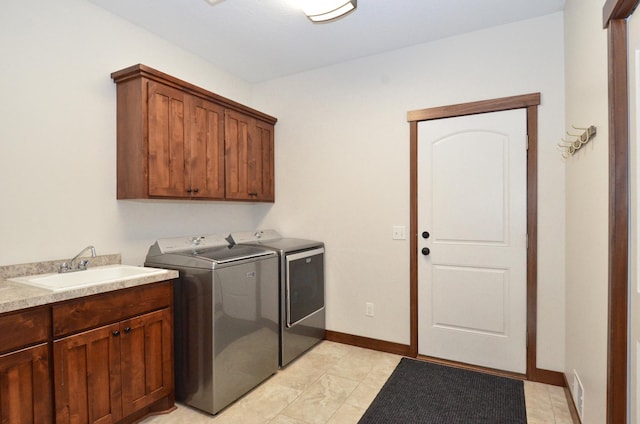 washroom featuring a sink, visible vents, baseboards, washer and dryer, and cabinet space